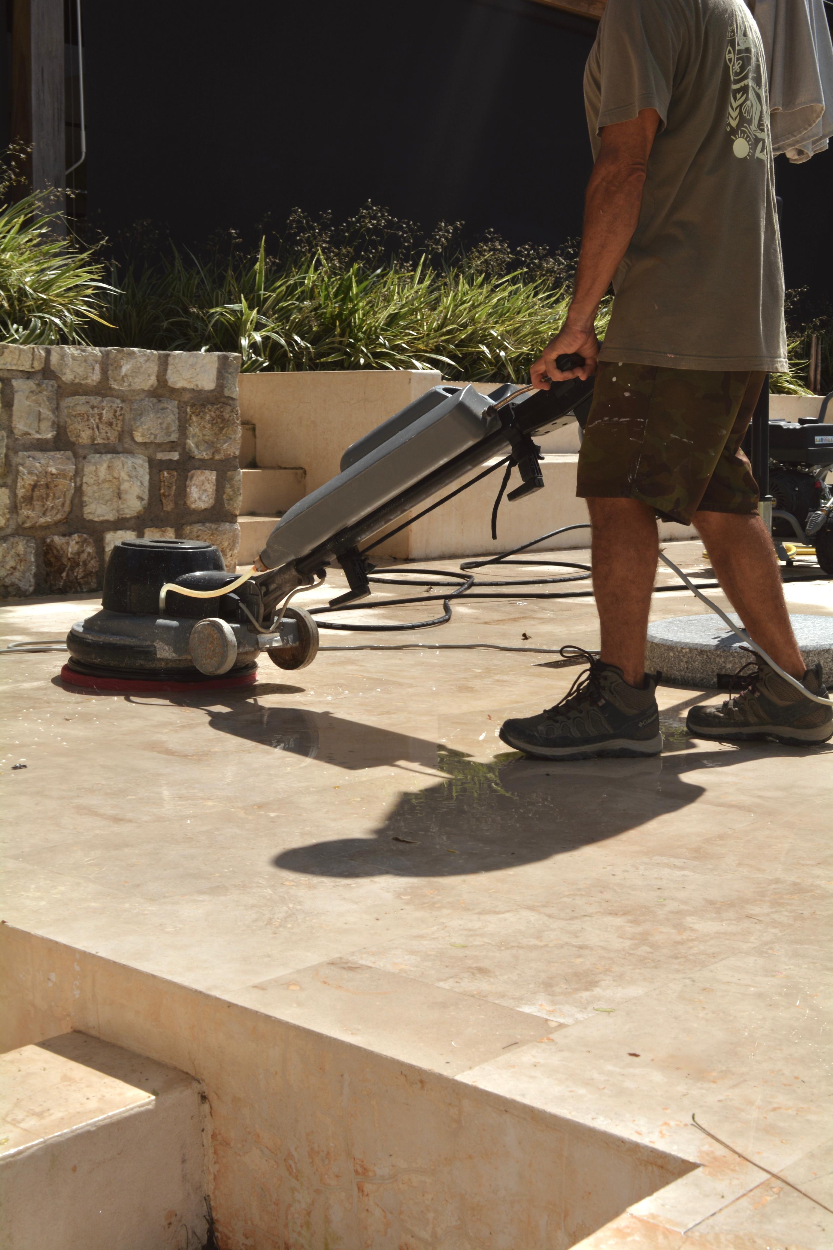 Soto Home Care technician polishing exterior natural stone near a residence in Nosara